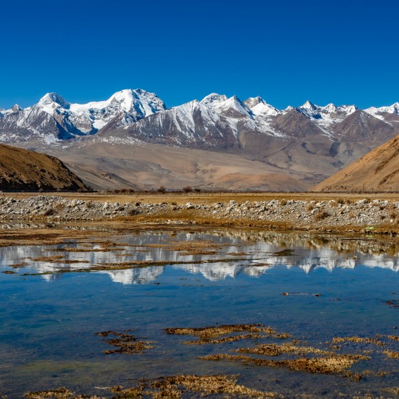 Montagne enneigée et ciel bleu qui se reflete dans un lac