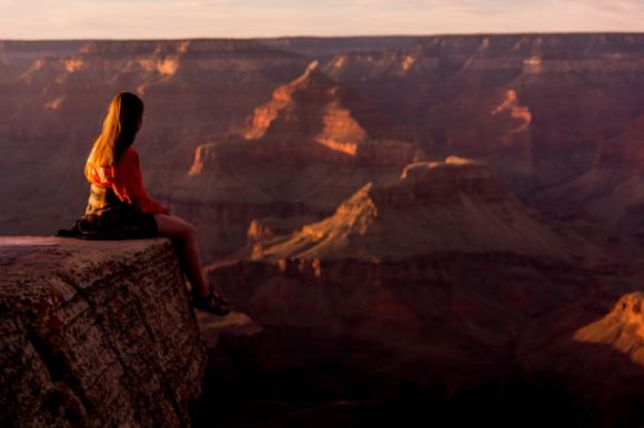 Femme méditant assise au bord d'un canyon