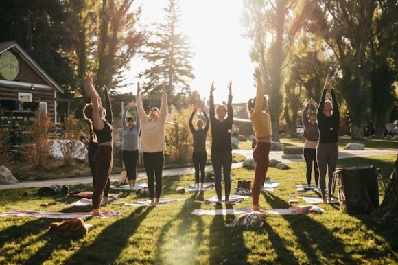 groupe de personnes qui font du yoga dans un parc